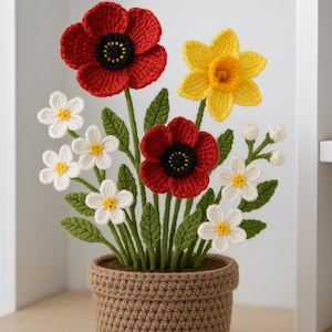 May include: A crocheted floral arrangement in a brown pot. The arrangement features red poppies with black centres, a yellow daffodil, and white daisies. Green leaves and stems support the flowers, creating a handmade, decorative piece.