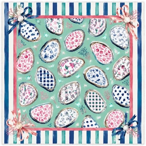 May include: A square throw blanket featuring a repeating pattern of oyster shells filled with various floral, gingham, and polka dot prints on a mint green background. The border has blue and teal stripes with bows at each corner.