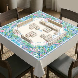 May include: A square mahjong table cover featuring a vibrant floral and botanical print in shades of blue, green, and pink. The center surface is cream-colored with printed game instructions, the letters WH, and several rows of mahjong tiles.
