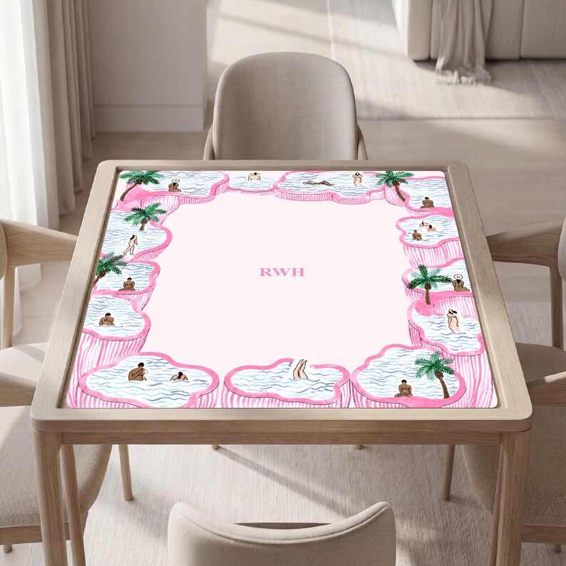 May include: A square table mat with a light pink center featuring the letters RWH in pink. The border consists of multiple irregular pink-rimmed pools filled with blue water, green palm trees, and small figures swimming or relaxing in the water.