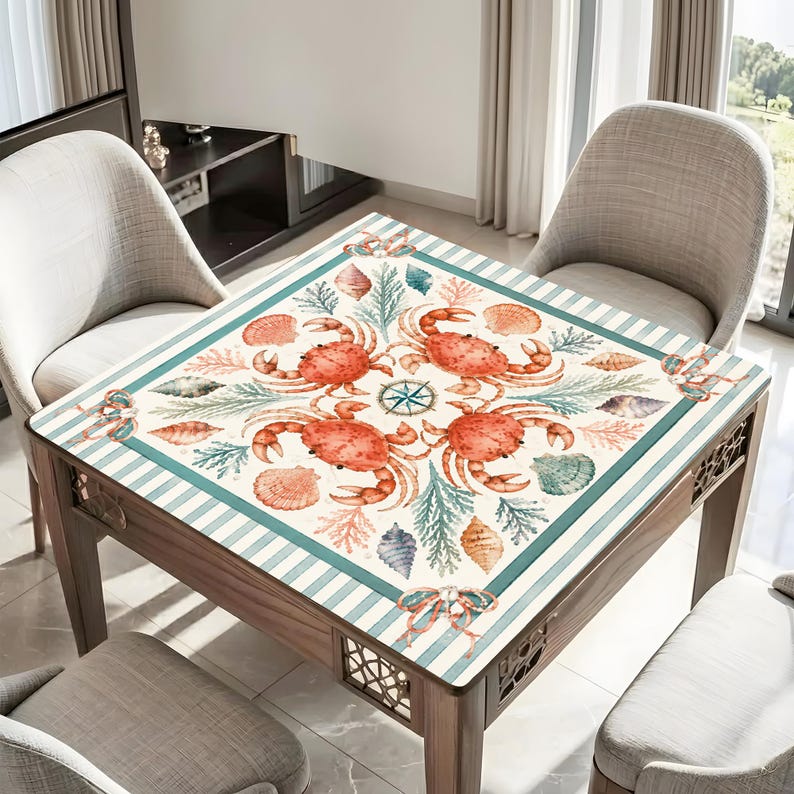 May include: A square wooden table with a nautical-themed design. The tabletop features a cream-colored background with a border of teal stripes. The design includes orange crabs, seashells, and a compass rose. The table has four legs and decorative cutouts.