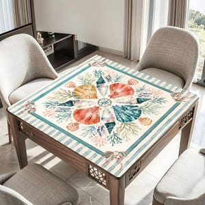 May include: A square wooden table with a nautical-themed design. The tabletop features a watercolor illustration of seashells, coral, and a compass rose in shades of orange, blue, and green. The table has a light blue striped border and decorative cutouts.
