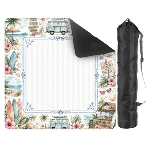 May include: A beach-themed picnic blanket with a blue and white striped center, surrounded by watercolor illustrations of surfboards, hibiscus flowers, and a vintage van. Includes a black carrying bag with a shoulder strap.