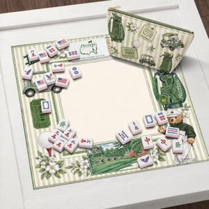 以下が含まれることがあります： ゴルフをテーマにしたゲームセット。ゴルフコースのシーンが描かれた装飾マット、ジッパー付きポーチ、ゲームタイルが含まれています。 マットには緑と白のストライプのボーダーがあり、「MASTERS」と「BIRDIE」の文字が書かれています。 ポーチにはゴルフ関連のグラフィックがあります。