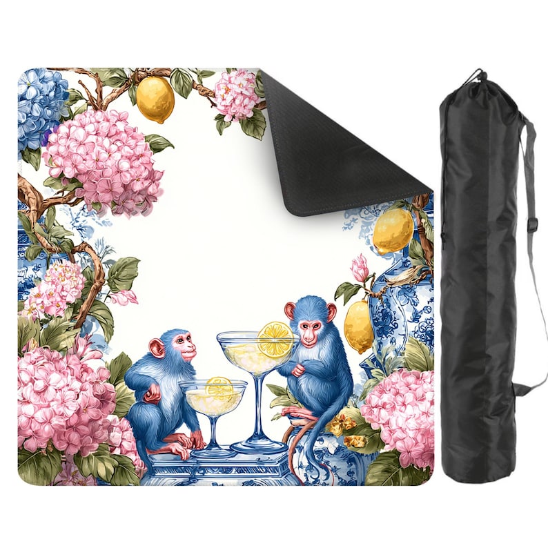 May include: A decorative yoga mat featuring a whimsical design with blue monkeys, cocktails, lemons, and pink hydrangeas. The mat has a black underside and comes with a black carrying bag. The design is set against a white background with blue and white porcelain-style accents.