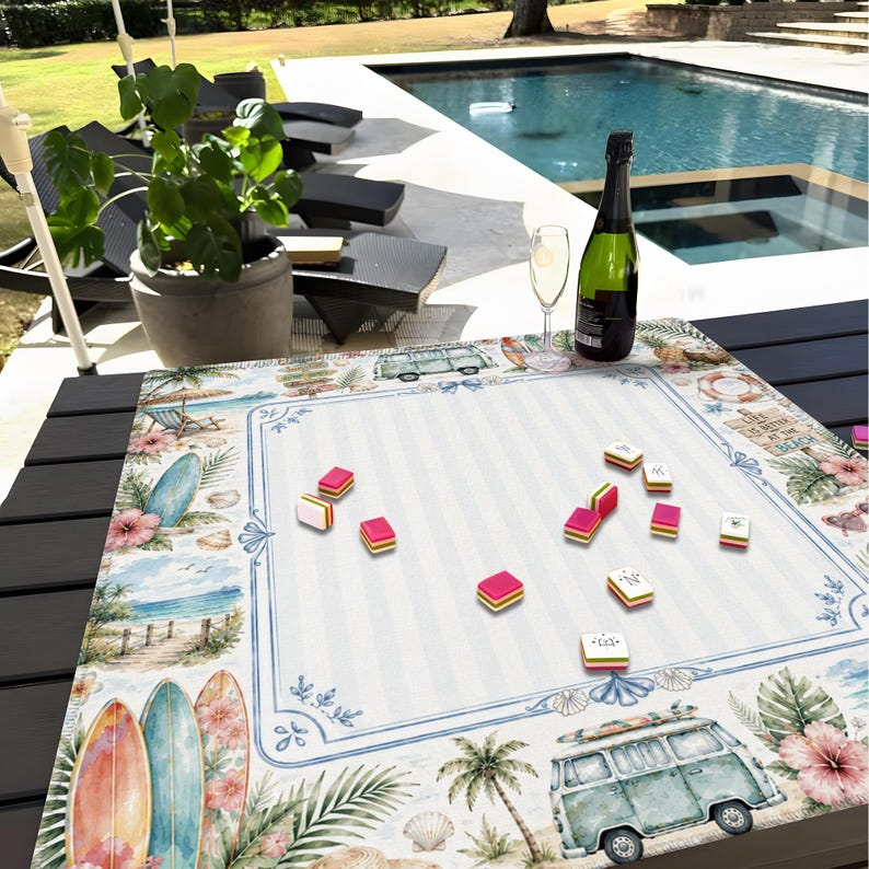 May include: A beach-themed game board with a blue and white striped center, surrounded by illustrations of surfboards, palm trees, and a vintage van. Pink and yellow game pieces are scattered across the board, with a bottle of champagne and a glass nearby.