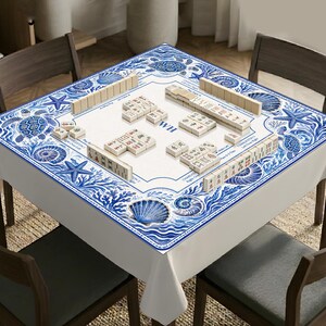 May include: A square mahjong table cover featuring a white center with game markings and the letters WH, surrounded by a blue and white border decorated with illustrations of sea turtles, starfish, seashells, and coral reef patterns.