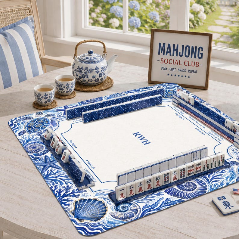 May include: A square mahjong mat with a blue and white sea life pattern featuring shells, starfish, and a turtle. The mat includes rows of mahjong tiles, a central monogram RWH, and a framed sign reading MAHJONG SOCIAL CLUB PLAY CHAT SNACK REPEAT.
