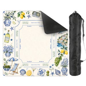 May include: A decorative game mat with a coastal theme, featuring illustrations of lemons, olives, and seaside scenes. The mat has a cream background with blue and white accents, and comes with a black carrying bag.