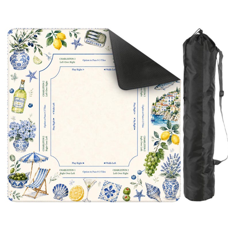 May include: A decorative game mat with a coastal theme, featuring illustrations of lemons, olives, and seaside scenes. The mat has a cream background with blue and white accents, and comes with a black carrying bag.
