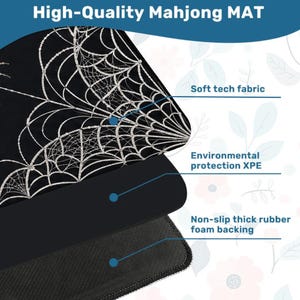 May include: A black Mahjong mat featuring a silver spider web pattern. The mat is composed of three layers: a soft tech fabric top, an environmental protection XPE middle layer, and a non-slip thick rubber foam backing for stability.