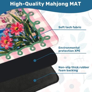 May include: A high-quality Mahjong mat with a floral design featuring pink and red flowers, a green border, and a pink and white checkered pattern. The mat has a soft tech fabric, environmental protection XPE, and a non-slip thick rubber foam backing.