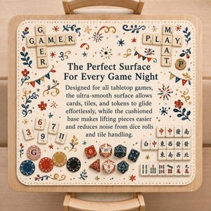 May include: A square game mat with a cream-coloured surface featuring floral patterns, bunting, and text that reads: The Perfect Surface For Every Game Night. The mat is decorated with scattered game tiles, numbered tokens, poker chips, and polyhedral dice.