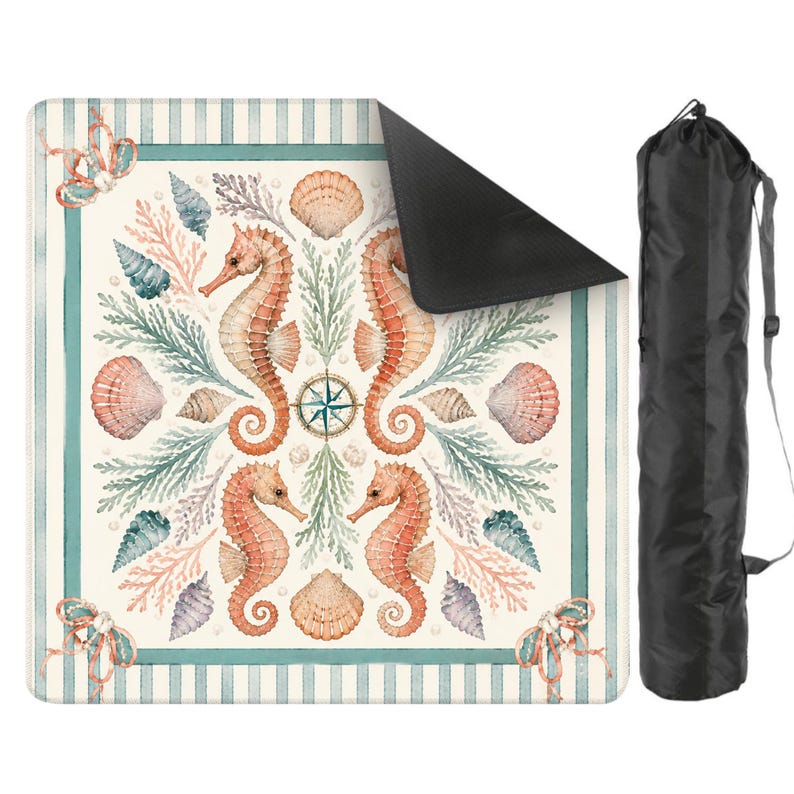 May include: A square beach mat with a nautical design featuring seahorses, seashells, and a compass rose. The mat has a cream background with a striped border in teal and white. A black carrying bag is included.