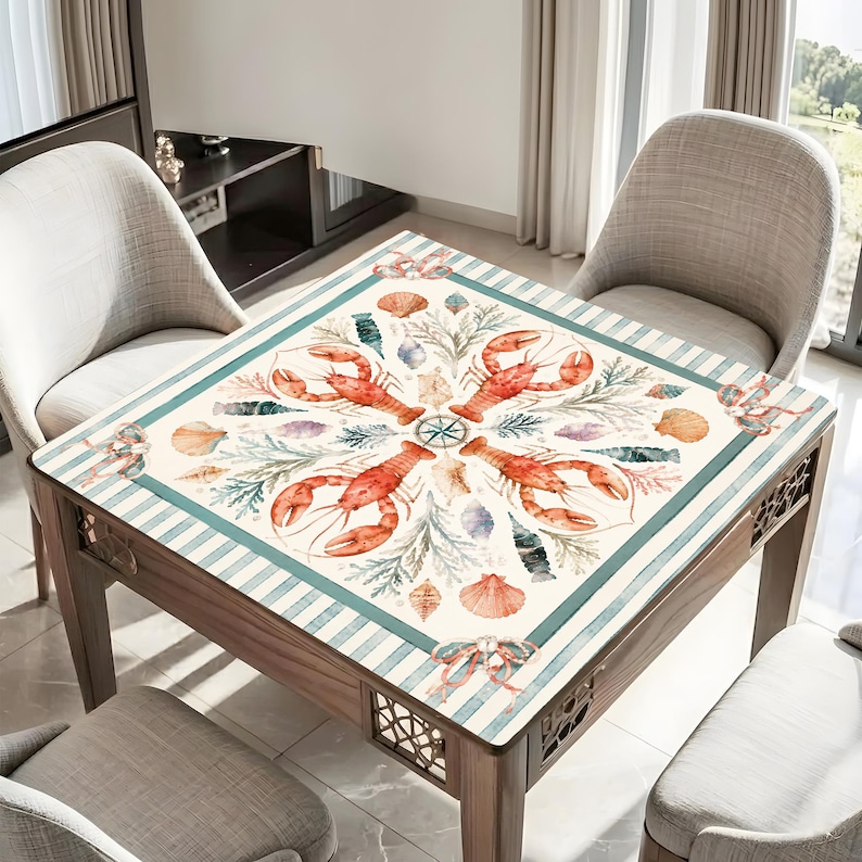 May include: Square wooden table with a marine-themed design. The tabletop features a pattern of red lobsters, seashells, and nautical elements on a cream background with teal stripes. The table has decorative cutouts on the sides and is surrounded by chairs.