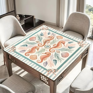May include: Square wooden table with a decorative top featuring a nautical design. The design includes orange seahorses, seashells, and coral on a cream background with teal stripes. The table has a wooden frame and decorative cutouts.