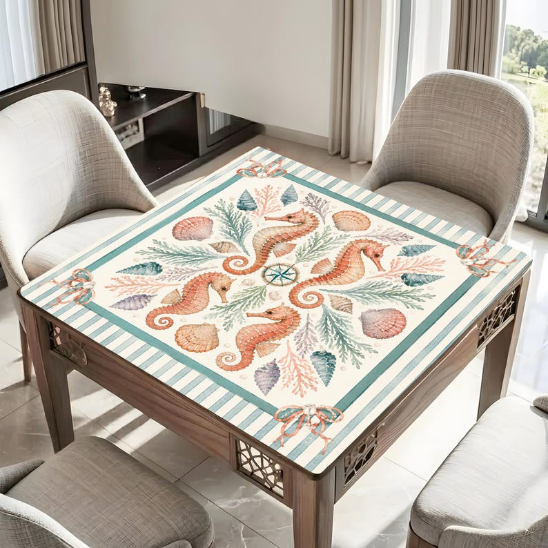 May include: Square wooden table with a decorative top featuring a nautical design. The design includes orange seahorses, seashells, and coral on a cream background with teal stripes. The table has a wooden frame and decorative cutouts.