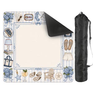 May include: A beach-themed picnic blanket with a blue and white striped border and illustrations of beach items. The blanket has a black underside and comes with a black carrying bag. The illustrations include hydrangeas, a seahorse, and a beach chair.