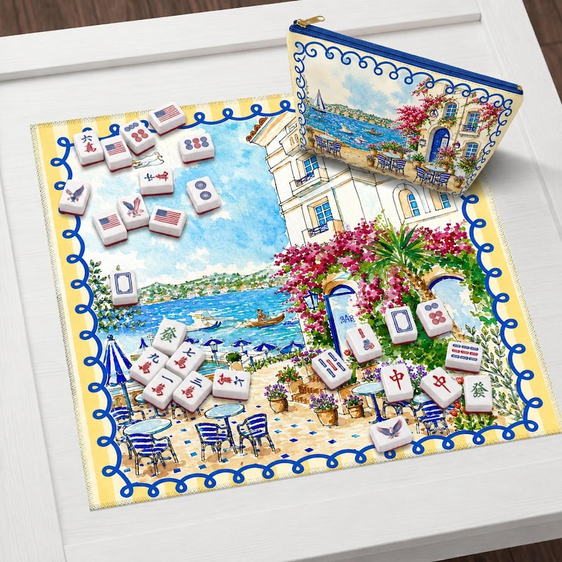 Puede incluir: Un juego de Mahjong decorativo con una bolsa con cremallera a juego. El juego incluye fichas con varios s&iacute;mbolos y dise&ntilde;os de la bandera estadounidense. La bolsa y la alfombra presentan una ilustraci&oacute;n costera esc&eacute;nica con detalles azules y rosas.