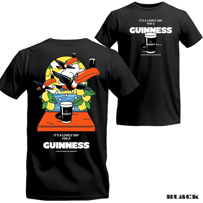 Peut inclure: T-shirt noir avec un motif Guinness. Le devant affiche le texte "It's a lovely day for a Guinness" et un dessin d'une pinte de Guinness. Le dos pr&eacute;sente une illustration color&eacute;e de toucans, de citrons et d'une pinte de Guinness.