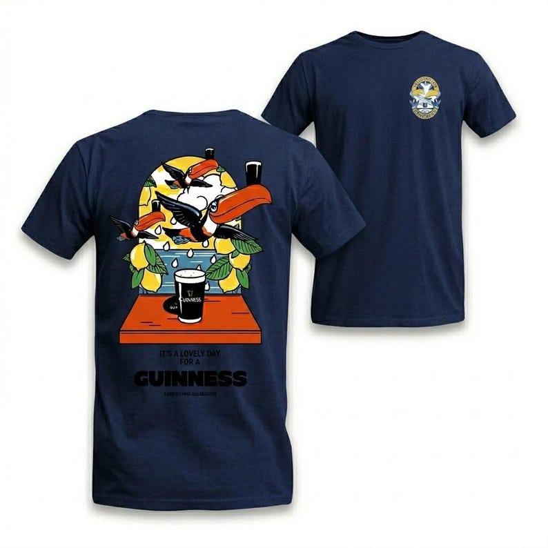 Puede incluir: Camiseta azul marino con un dise&ntilde;o colorido de tucanes, limones y una pinta de Guinness. La parte trasera de la camiseta tiene la frase "It's a lovely day for a Guinness". Un peque&ntilde;o emblema est&aacute; en la parte delantera.