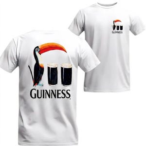 May include: White t-shirt featuring a toucan with a large orange beak, two dark pints of stout, and the Guinness logo. A smaller version of the design is on the front. The shirt is a classic crew neck.