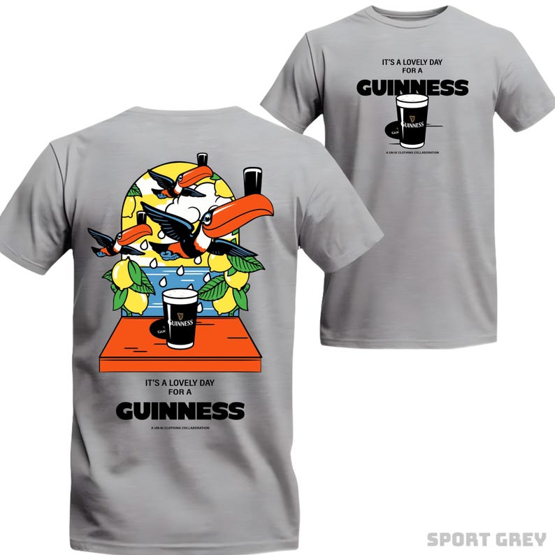 Peut inclure: T-shirt gris sport avec un motif Guinness. L'avant pr&eacute;sente un verre de Guinness et le texte "IT'S A LOVELY DAY FOR A GUINNESS". Le dos montre des toucans, des citrons et un verre de Guinness. Une collaboration vestimentaire amusante.