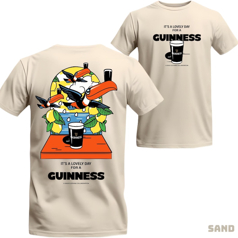 Peut inclure: T-shirt couleur sable avec un motif Guinness. L'avant affiche un verre de Guinness et le texte "IT'S A LOVELY DAY FOR A GUINNESS". Le dos pr&eacute;sente des toucans, des citrons et un verre de Guinness. Un t-shirt d&eacute;contract&eacute; et amusant.