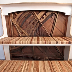 May include: A white bench with two shelves made from repurposed piano parts. The shelves are made of wood and have a natural finish. The bench is a unique and stylish piece of furniture that would be perfect for any home.