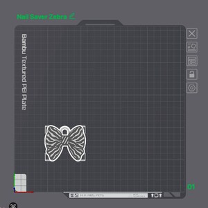 May include: A digital interface display showing a 3D printing build plate with the text Nail Saver Zebra and Bambu Textured PEI Plate. A white outline of a bow-shaped object with a zebra stripe pattern is positioned on the dark gray grid.