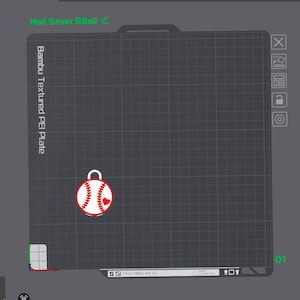 May include: A digital interface showing a Bambu Textured PEI Plate with a grid layout. A white baseball graphic with red stitching and a small red heart is positioned on the plate. The text Nail Saver BBall is visible at the top left corner.