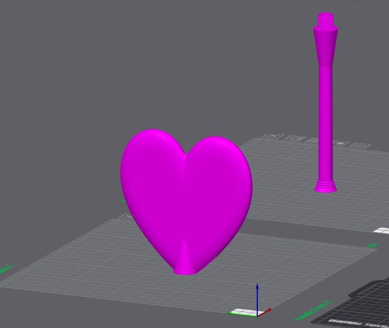 May include: A vibrant magenta heart shape and a tall, slender magenta object with a threaded top are displayed on a gray surface. The heart is smooth and three-dimensional, while the other object has a cylindrical base and a tapered design.