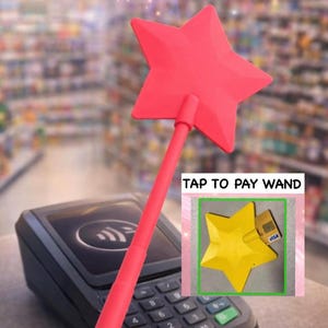 May include: A pink star-shaped wand with a long handle, positioned over a payment terminal. The image includes a smaller inset showing a yellow star-shaped object with a credit card. Text on the inset reads "TAP TO PAY WAND".