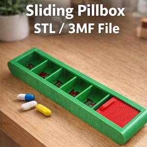 Pode incluir: Caixa de comprimidos deslizante verde com tampa deslizante vermelha e compartimentos para cada dia da semana. O texto "Sliding Pillbox STL / 3MF File" é exibido acima. Três comprimidos azuis, brancos e amarelos estão ao lado.
