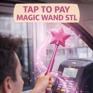 May include: A pink magic wand with a star-shaped head is held near a payment terminal. The wand has a metallic finish and is surrounded by pink sparkles. The text "TAP TO PAY MAGIC WAND STL" is displayed above.