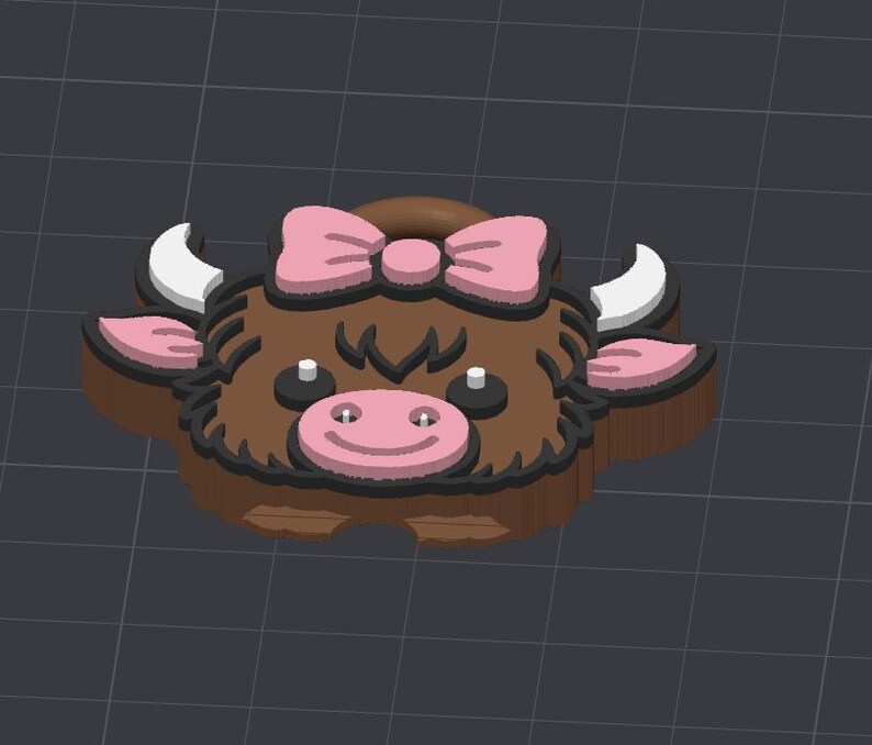 May include: A 3D-printed cow-shaped object with a brown body, pink bow, and pink ears. The cow has white horns, black eyes, and a pink nose with a smiling mouth. The object is designed with a dark outline.