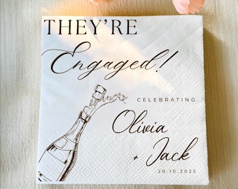 May include: White square paper napkin with the text "THEY'RE Engaged!" in elegant script. A champagne bottle illustration is featured, with the names Olivia and Jack, and the date 20.10.2025. Perfect for an engagement celebration.