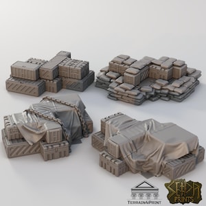 May include: A selection of grey miniature military storage containers and sandbag structures. Some are stacked, others draped with fabric and secured with chains. The scene suggests a tabletop gaming or model-making theme.