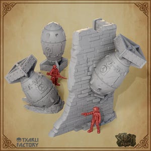 Peut inclure: Modèles miniatures gris d'une bombe, d'un mur de briques et de deux figurines de soldats rouges. Les bombes ont un design riveté et une queue en forme d'hélice. Le mur de briques est partiellement détruit. Les textes "TXARLI FACTORY" et "SERA PRINTS" sont visibles.