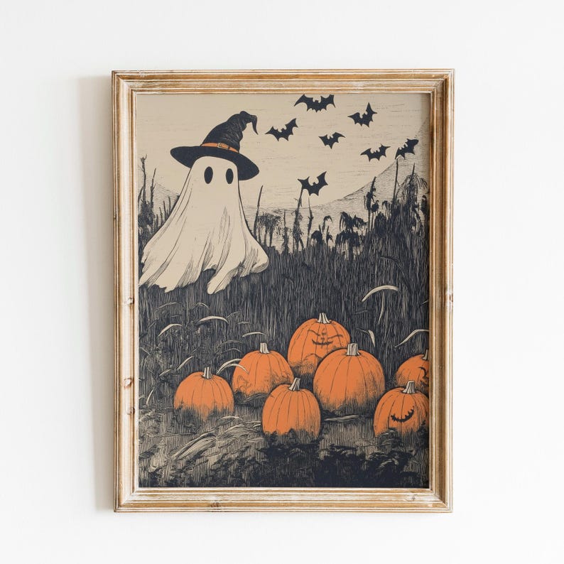 Puede incluir: Una impresi&oacute;n enmarcada con tem&aacute;tica de Halloween que presenta un fantasma con un sombrero de bruja, calabazas naranjas y murci&eacute;lagos. La obra de arte tiene un estilo vintage con una paleta de colores apagados en beige, negro y naranja.
