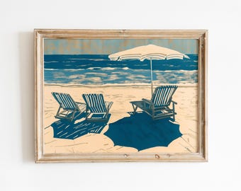 May include: A framed art print depicting a beach scene with two striped lounge chairs and a matching striped beach umbrella on a sandy shore. The ocean is rendered in deep blue tones, and the shadows cast by the furniture are dark blue.