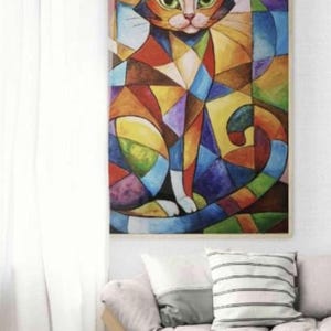 May include: A framed abstract painting of a cat. The cat is depicted in a geometric style with a colorful patchwork of shapes in shades of orange, blue, green, and brown. The cat is sitting with its tail curled.