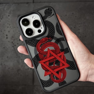 Op de afbeelding: Een zwarte telefoonhoes met een grafisch ontwerp van een rode slang die om een rode zespuntige ster is gewikkeld. De achtergrond van de hoes is doorschijnend grijs en het ontwerp bevat een tweede zwart slangenpatroon achter de rode slang.