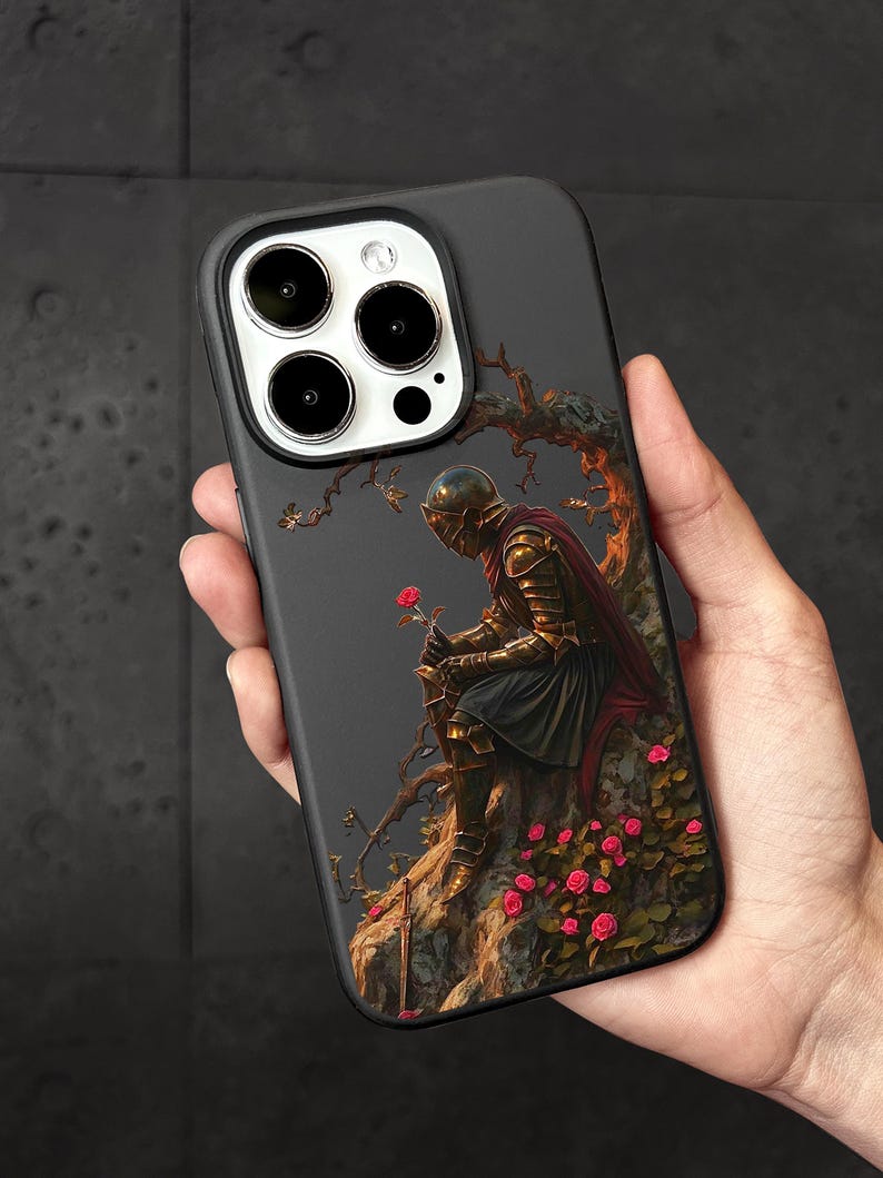 A person's hand holding a phone case with a painting of a knight in armor sitting on a rock, surrounded by flowers.
