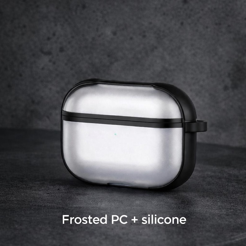 A silver and black earbud case with a frosted PC+ silicone design, sitting on a dark surface.