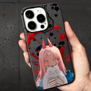 May include: Black phone case featuring a colorful anime illustration. The design includes a pink-haired character with horns holding a white cat, set against a dark background with red accents.