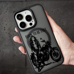 May include: A grey phone case with a black illustration of a woman on a motorcycle. The text "BORN TO BE FREE" is above the image. The case has a black border and a grey back.