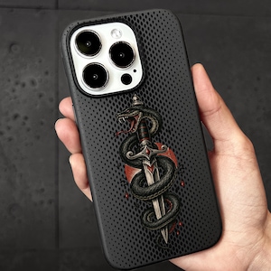 Peut inclure: Une coque de smartphone noire avec un motif à pois texturé présentant un graphique central d'un serpent noir enroulé autour d'une dague argentée avec des accents rouges, sur un élément d'arrière-plan circulaire rouge au dos de l'appareil.