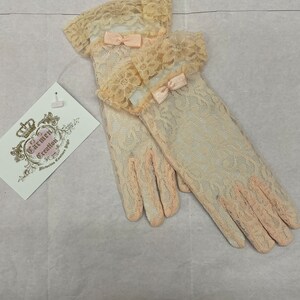 May include: A pair of ivory lace gloves with delicate pink bows. The gloves have a scalloped lace trim at the top and are made of a fine, sheer fabric.