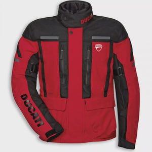 Puede incluir: Chaqueta de moto roja y negra con la palabra "DUCATI" impresa en la manga. La chaqueta tiene un cuello alto, múltiples bolsillos y el logotipo de Ducati en el pecho. La chaqueta está diseñada para montar en moto.